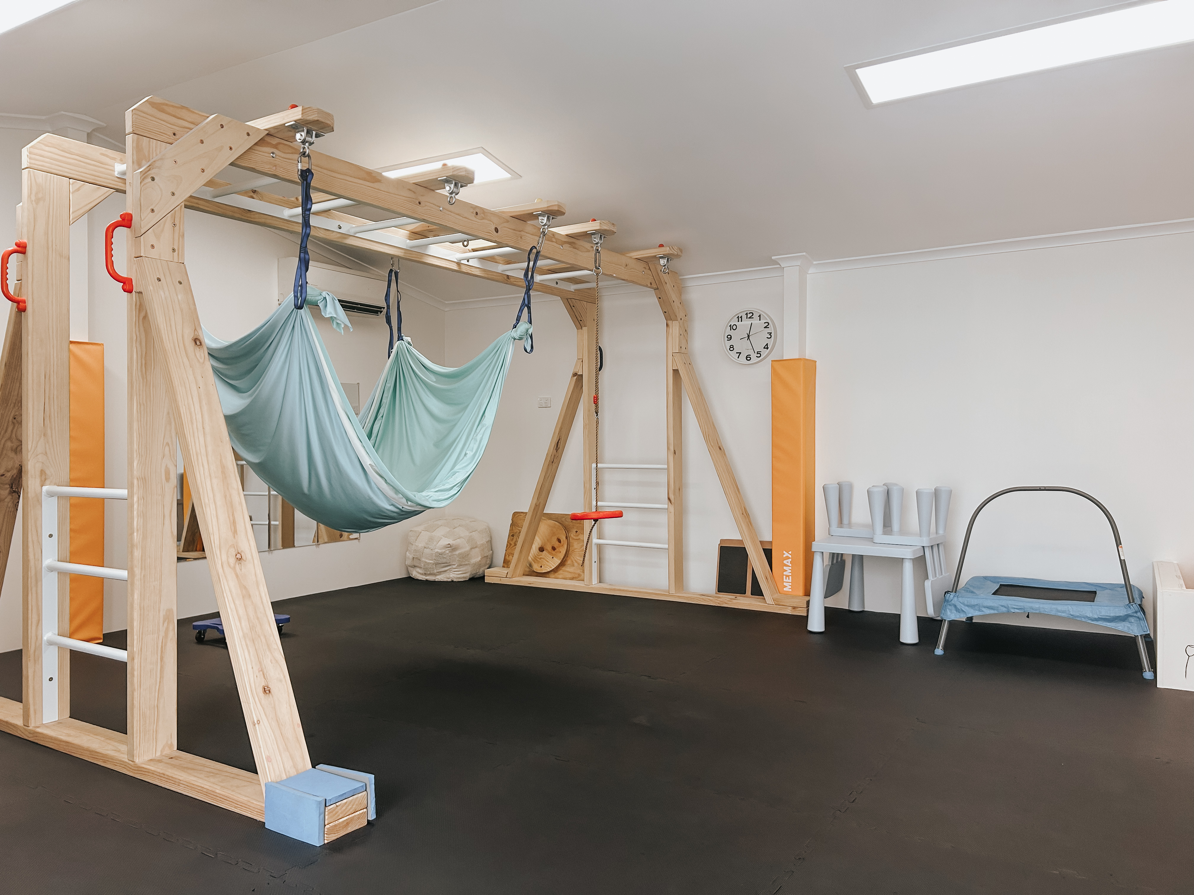 Wide view of the studio corner with lycra hammocks, monkey bars, and kids' chair